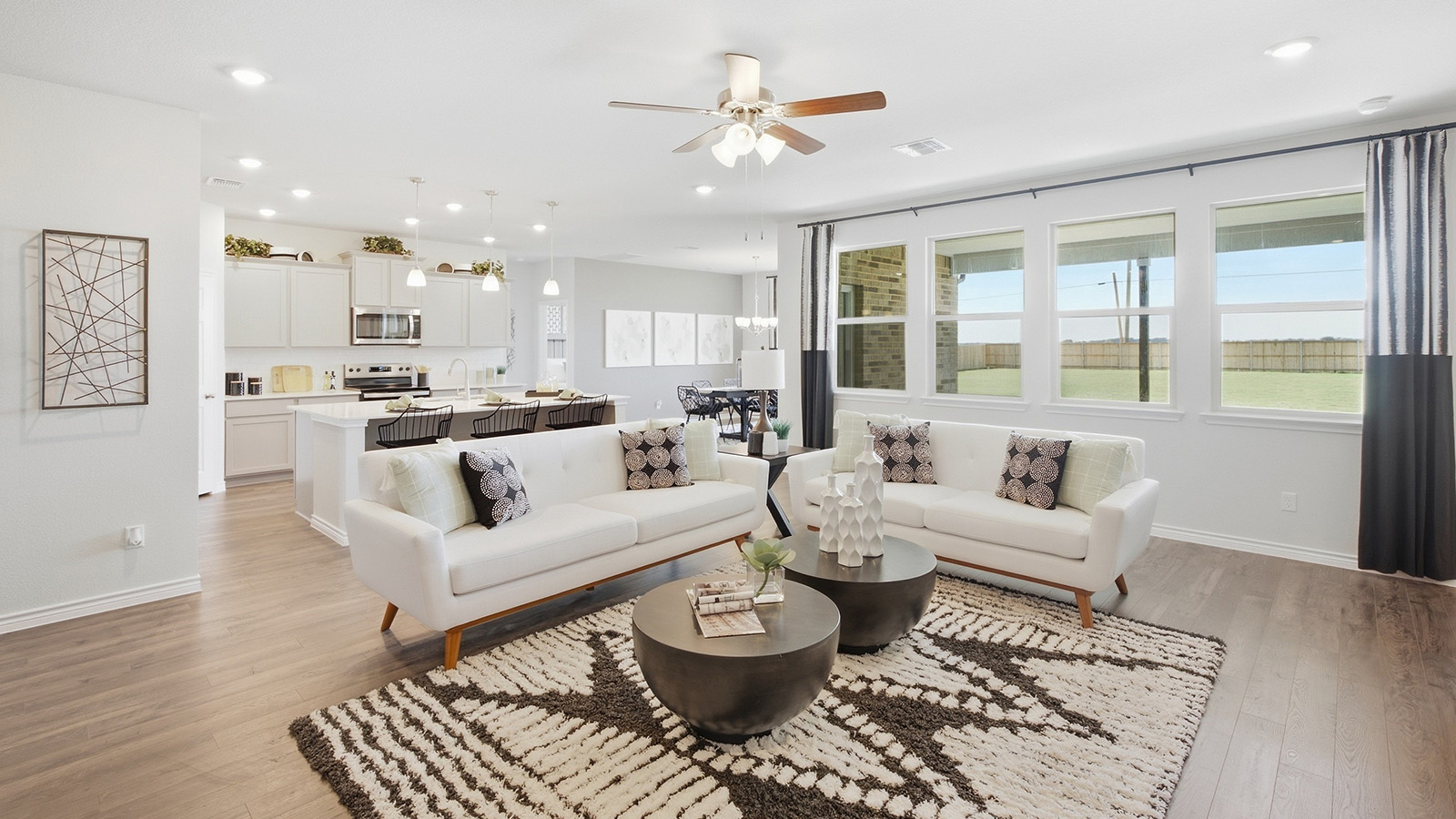 Homestead Model living room with view of open concept dining room and kitchen.