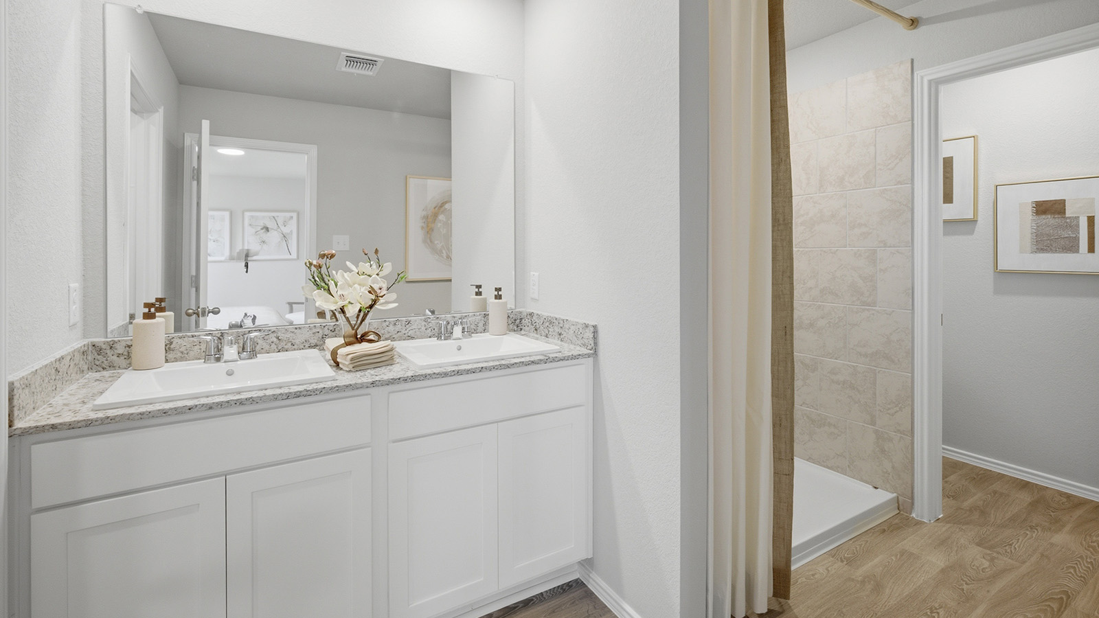 Cool Water model primary bathroom with duel vanity sink and walk-in shower.