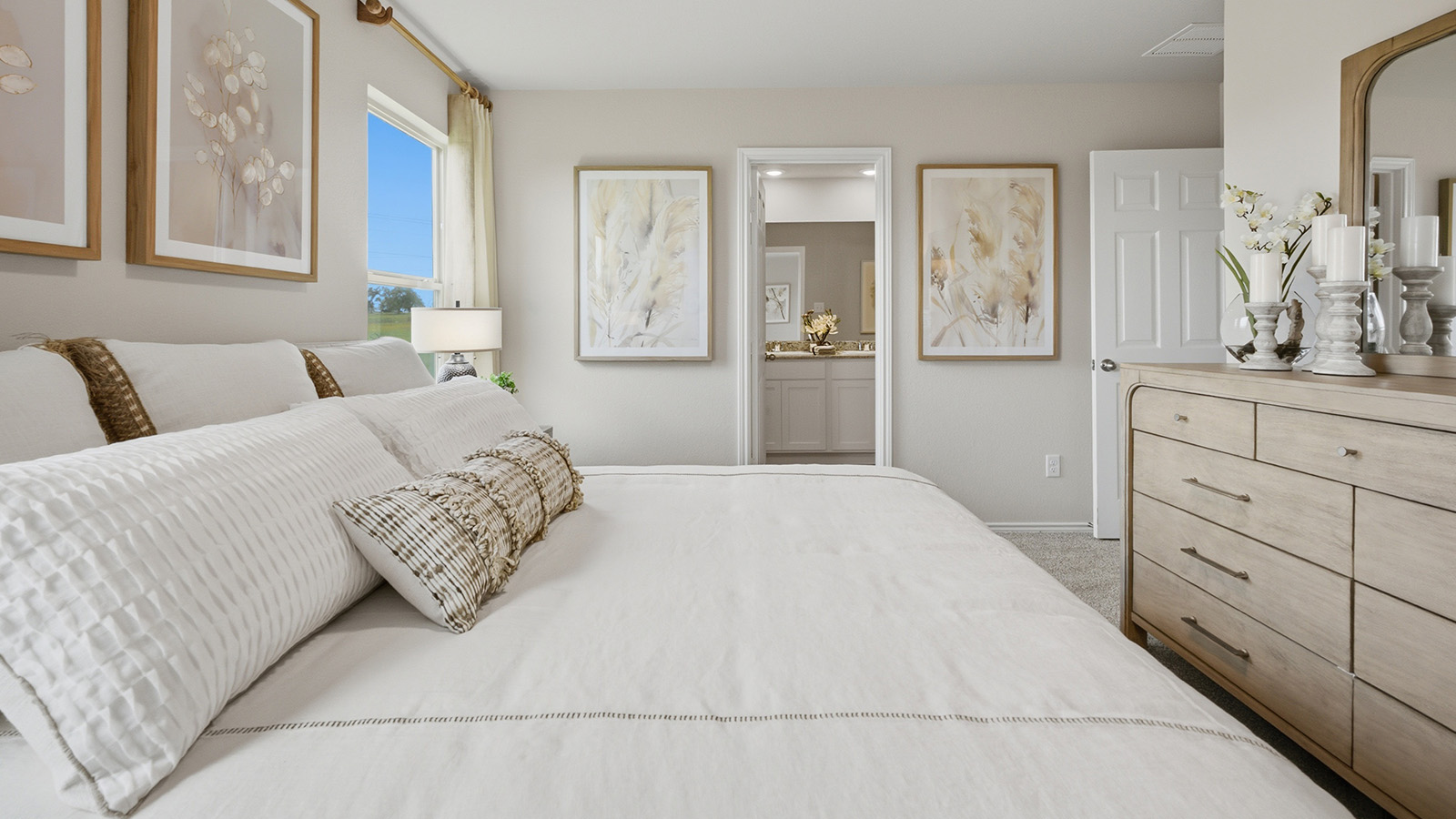 Cool Water model primary bedroom with carpeted flooring and view of primary bathroom.