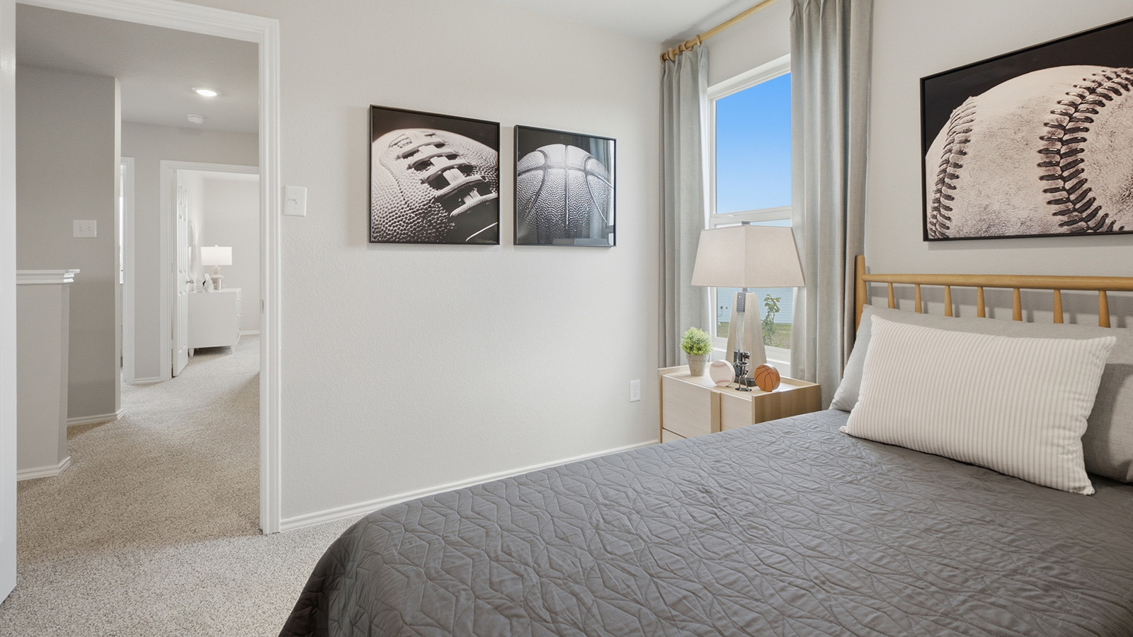 Cool Water model secondary bedroom with carpeted flooring and view of hallway.