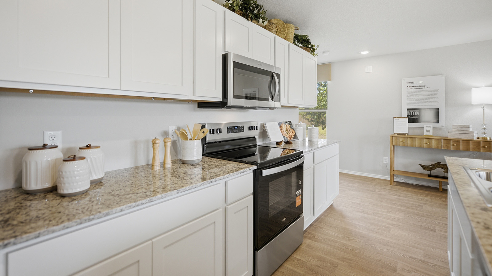 Cool Water model home kitchen with white cabinets and granite countertops.