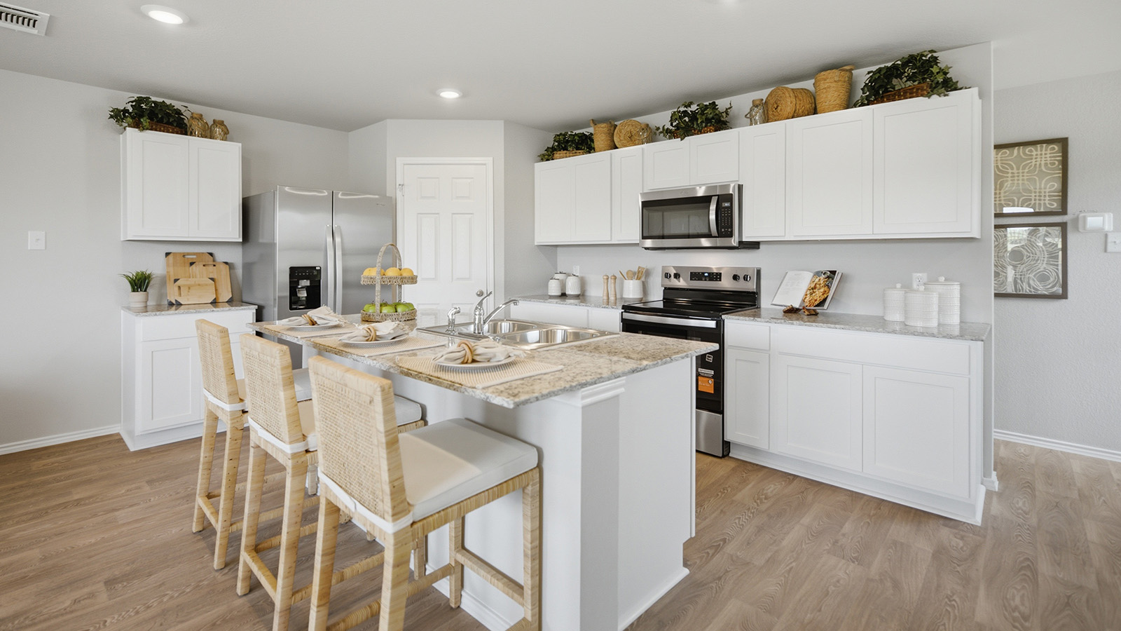 Cool Water model home kitchen with white cabinets and granite countertops.