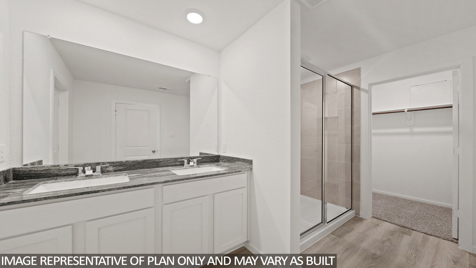 Gardenia primary bathroom with double vanity sink and walk-in shower with view of walk-in closet.