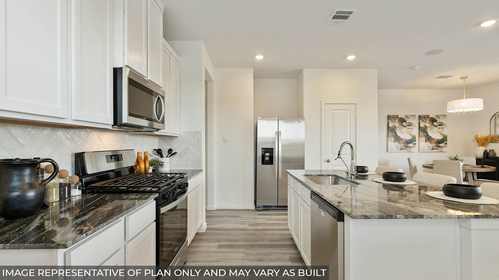 Hibiscus kitchen with light cabinets and dark countertops with view of dining room.