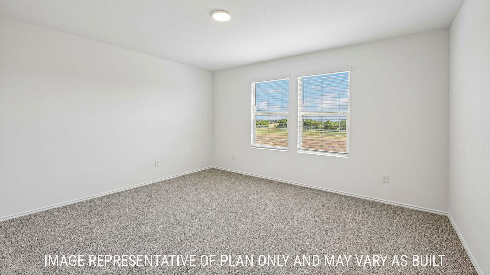 Hibiscus primary bedroom with carpeted flooring and windows for natural lighting.