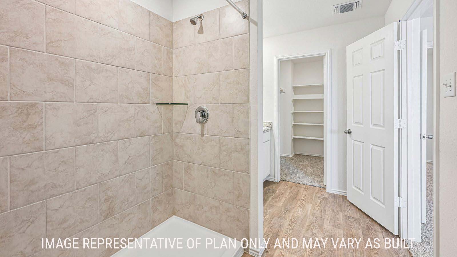 Hibiscus primary bathroom with walk-in shower and view of primary bedroom walk-in closet.