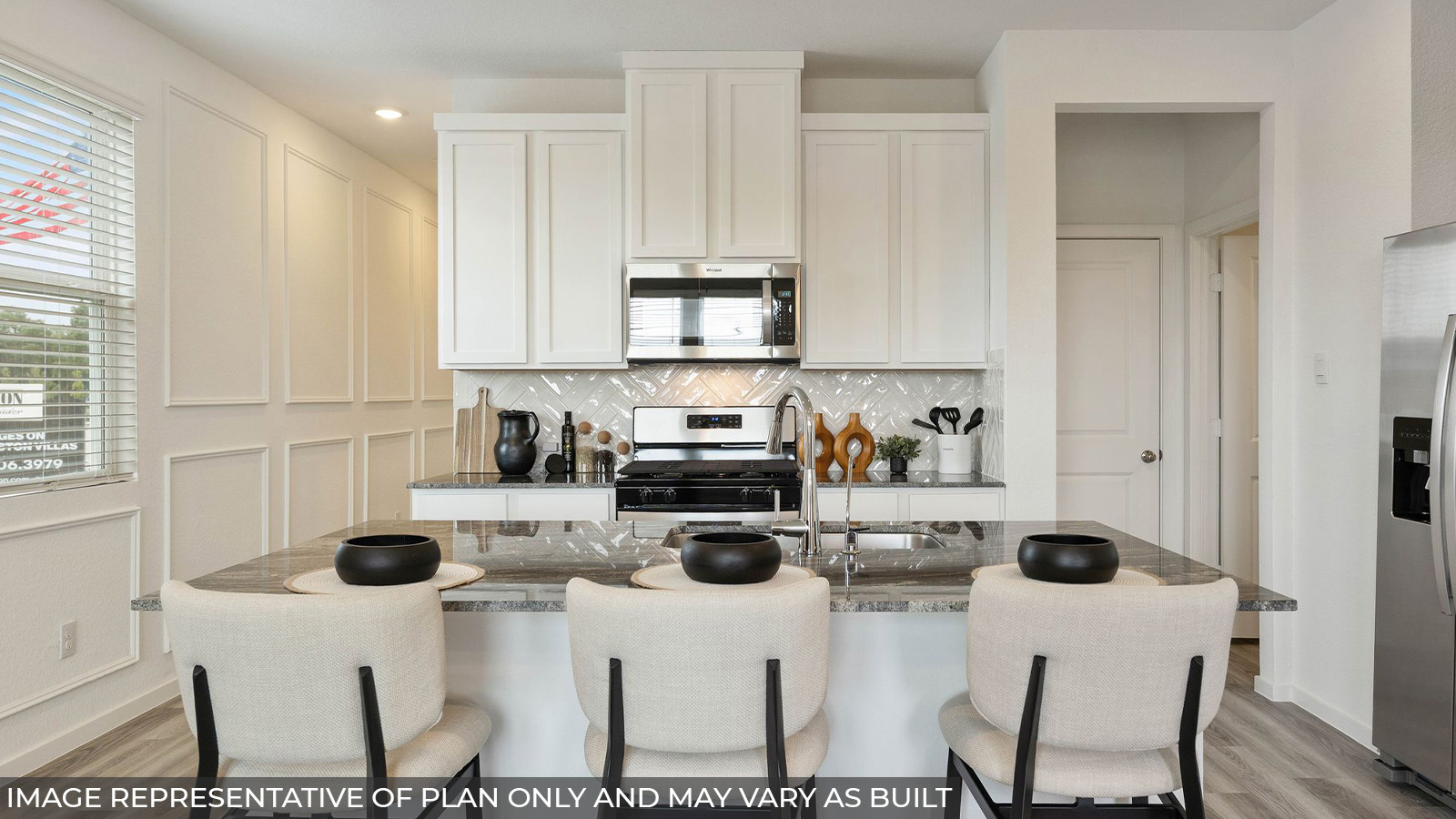 Hibiscus kitchen with light cabinets and dark countertops with vinyl plank flooring.