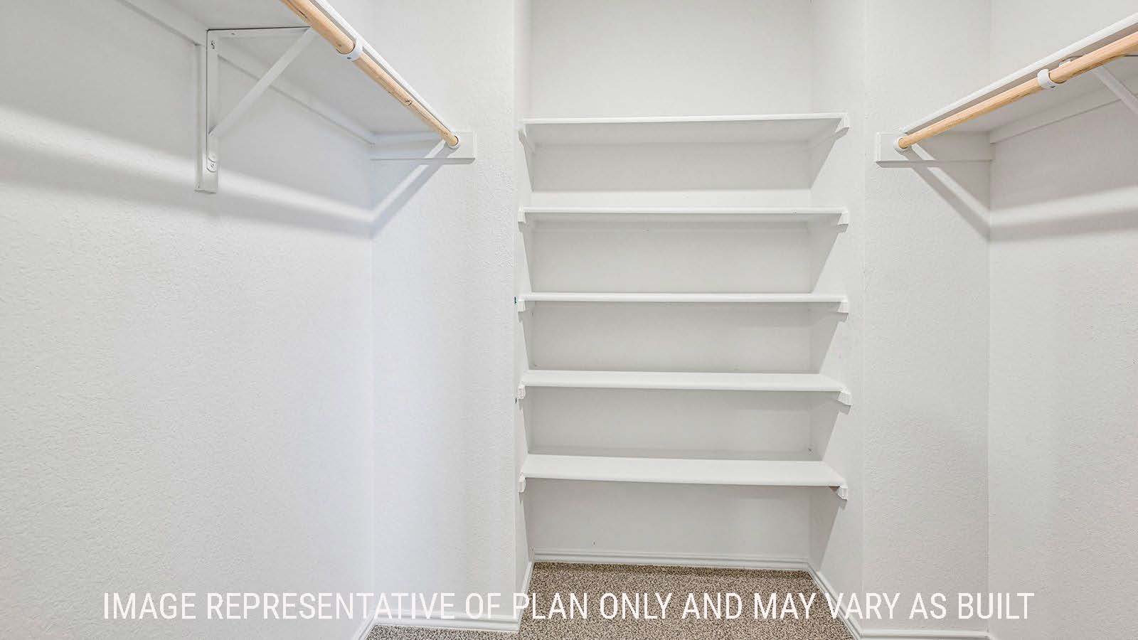 Hibiscus primary bedroom walk-in closet with carpeted flooring and shelving for storage.