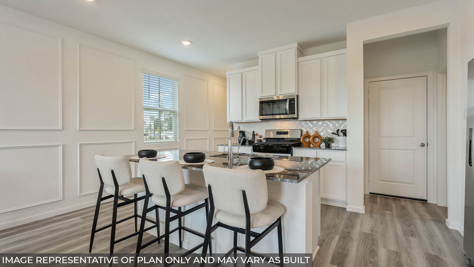 Hibiscus kitchen with light cabinets and dark countertops with vinyl plank flooring.