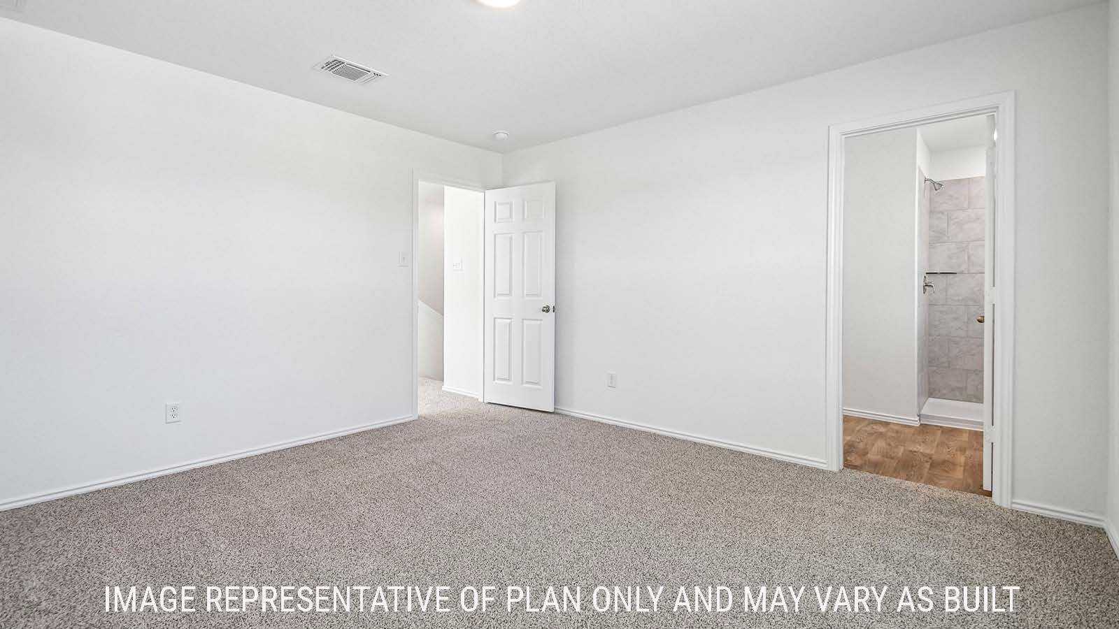 Iris primary bedroom with carpeted flooring and view of primary bathroom.