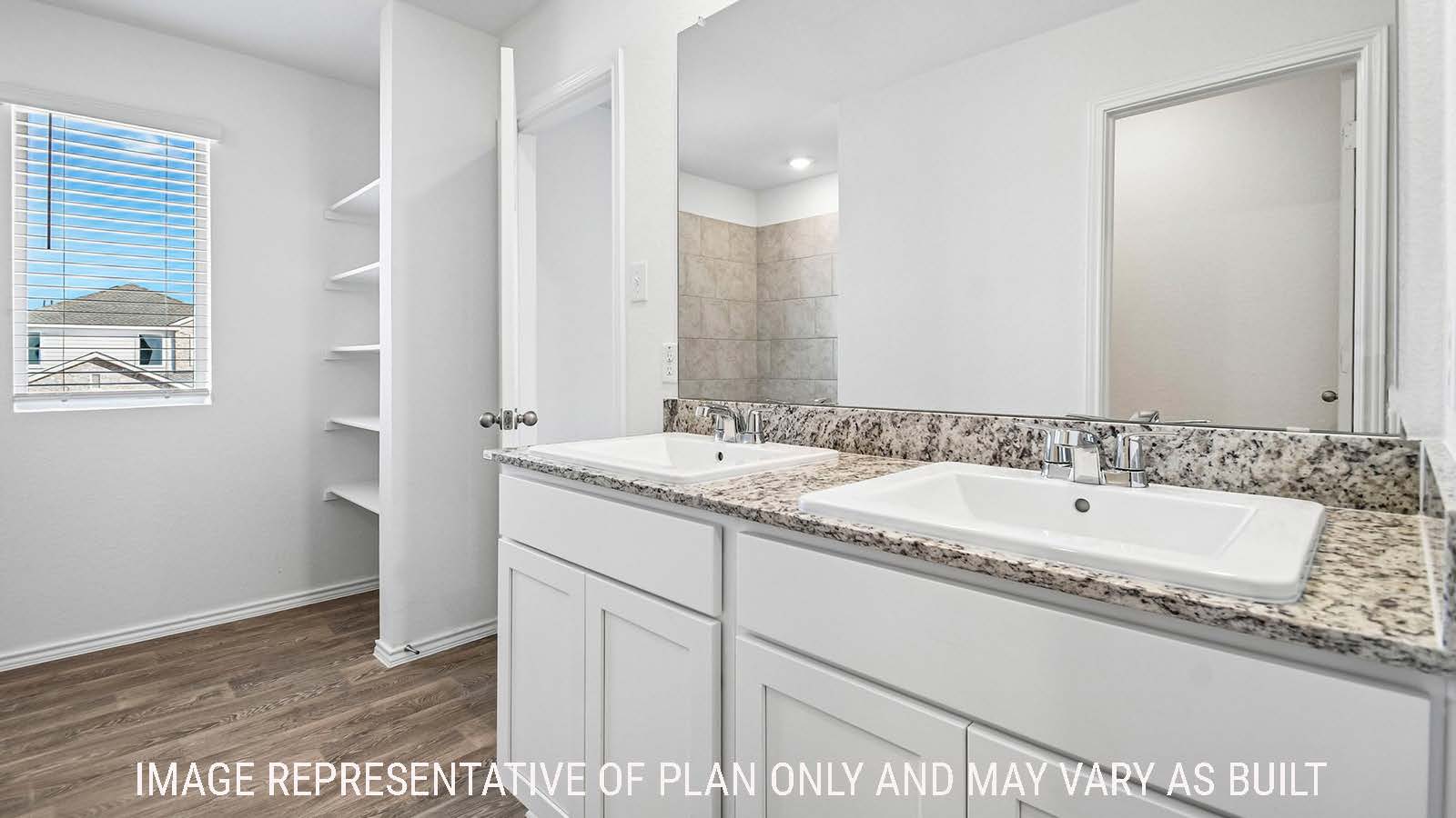 Iris primary bathroom with double vanity sink and shelving for storage.
