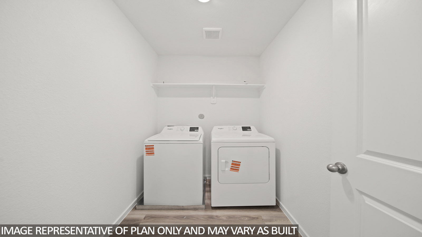 Iris utility room with washer and dryer and shelving for storage.