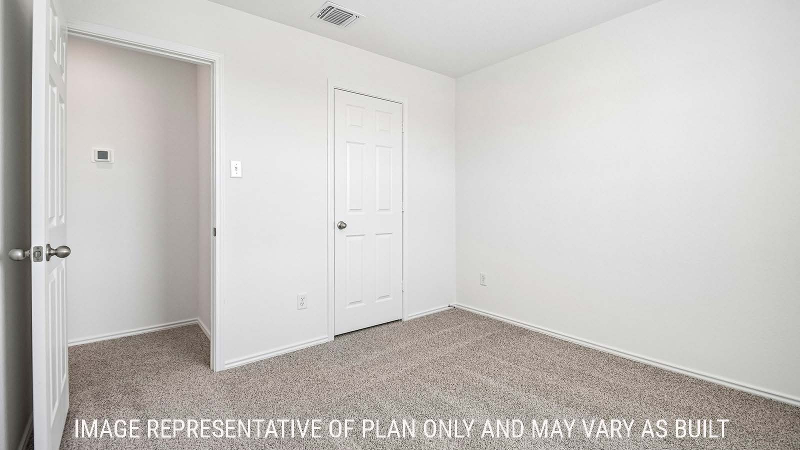 Iris secondary bedroom with carpeted flooring and view of hallway to game room.