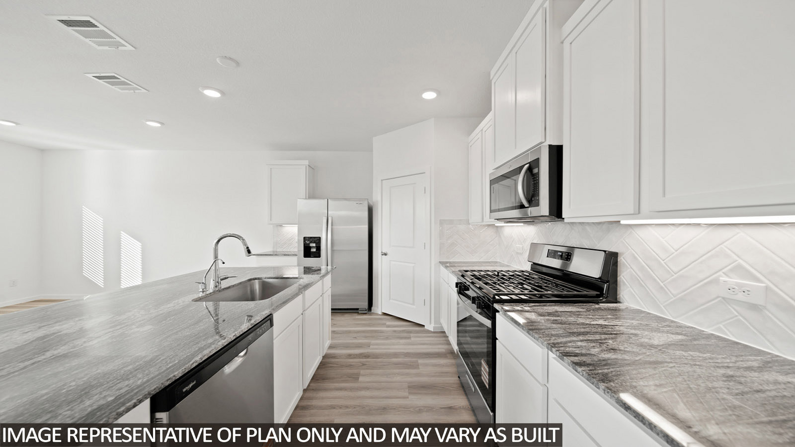 Iris kitchen with light cabinets and dark countertops with view of open concept dining room.