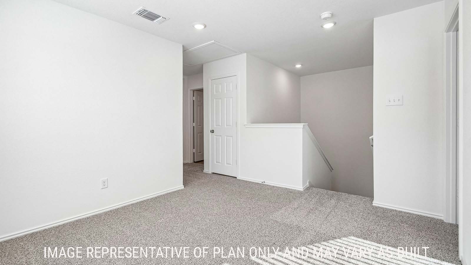 Iris game room with carpeted flooring and view of secondary bedroom and stairs to first floor.