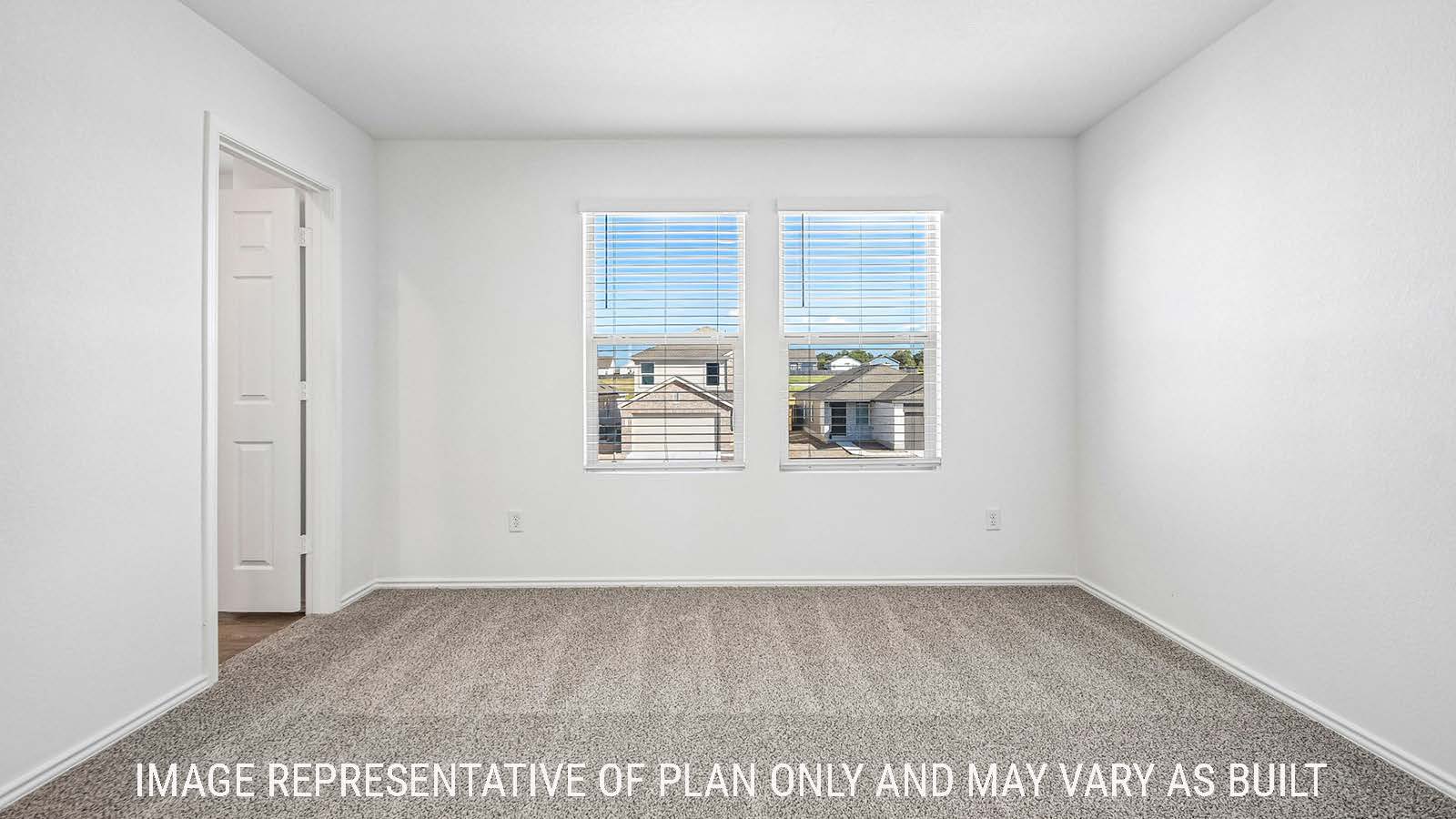Iris primary bedroom with carpeted flooring and windows for natural lighting.