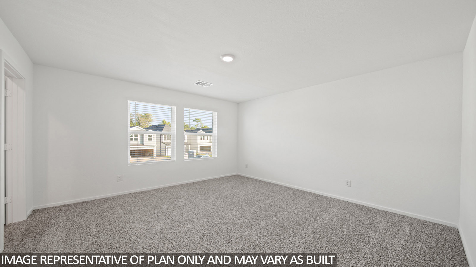 Iris primary bedroom with carpeted flooring and windows for natural lighting.