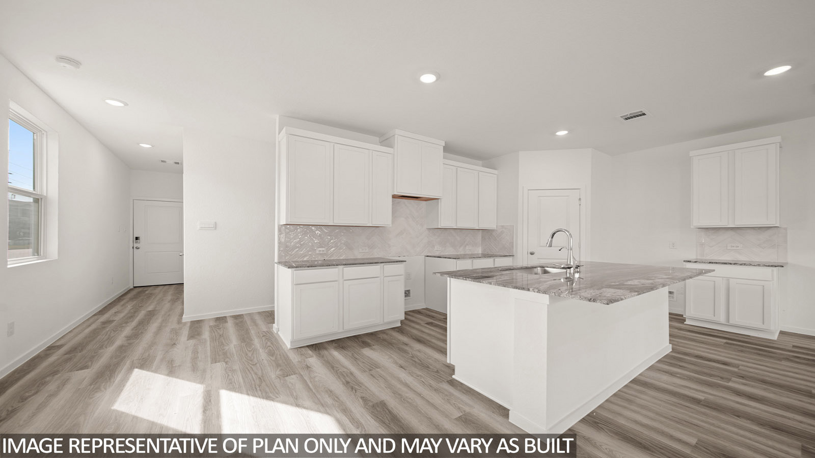 Jasmine kitchen with kitchen island with light cabinets and dark countertops and view of entry.