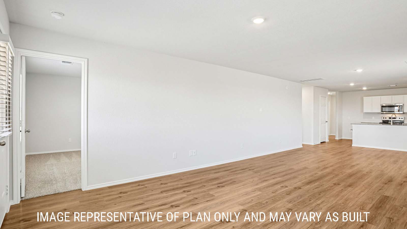 Estero living room with vinyl plank flooring and view of primary bedroom.