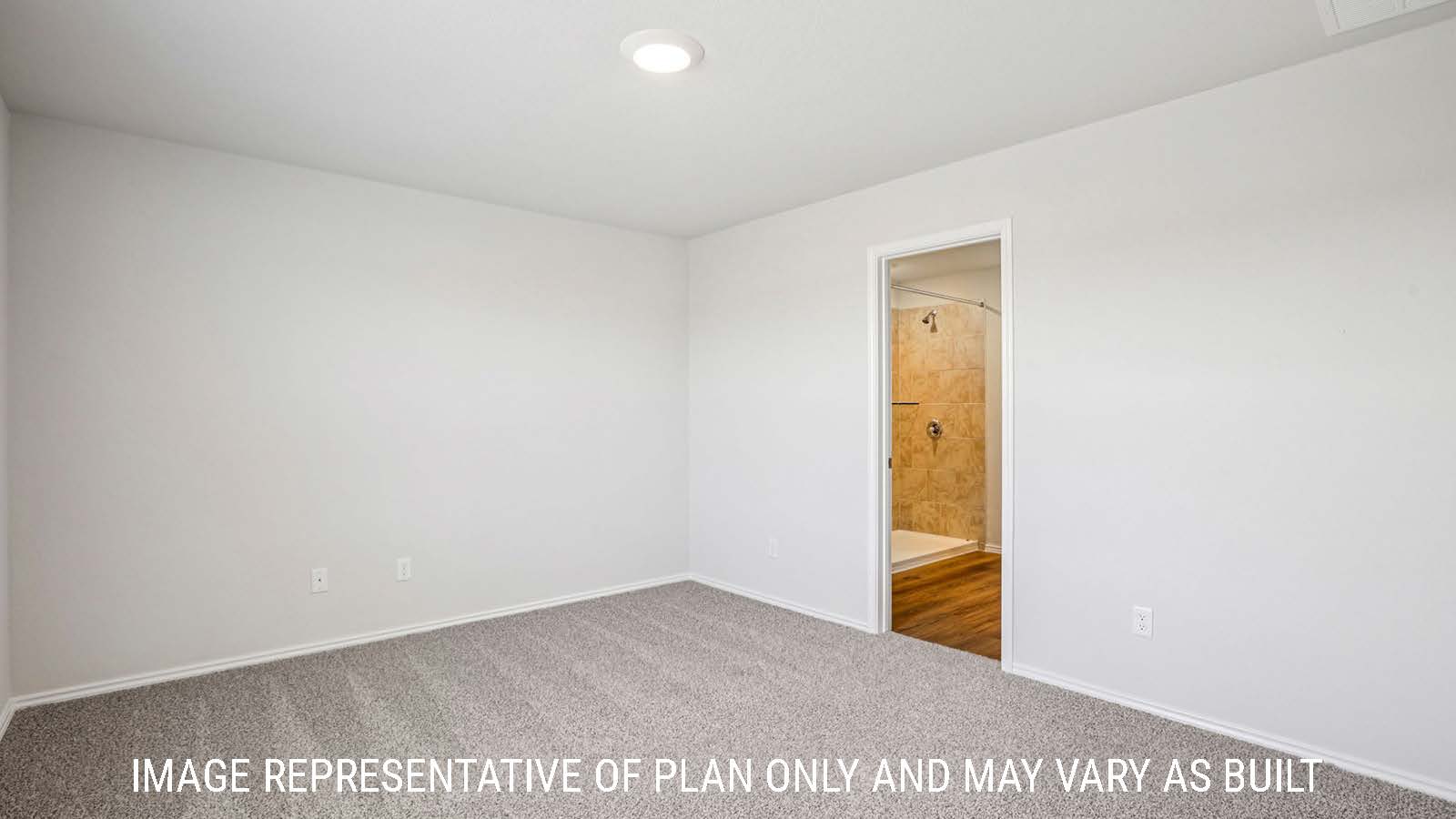 Estero primary bedroom with carpeted flooring and view of primary bathroom.