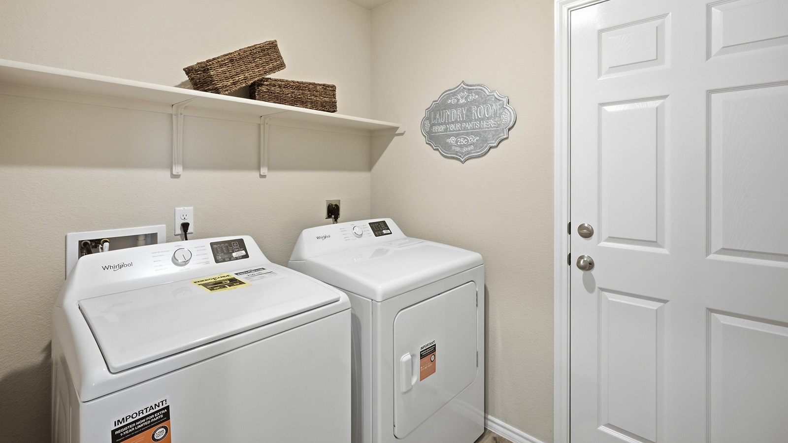 Hidden Trails Model Home utility room with washer and dryer and shelving for storage.