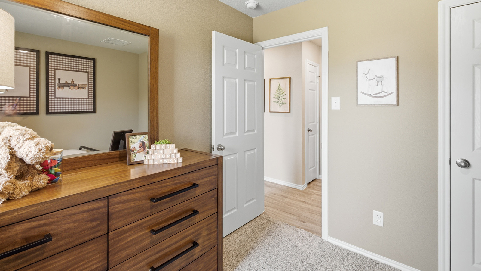 Hidden Trails Model Home secondary bedroom with carpeted flooring and view of hallway.