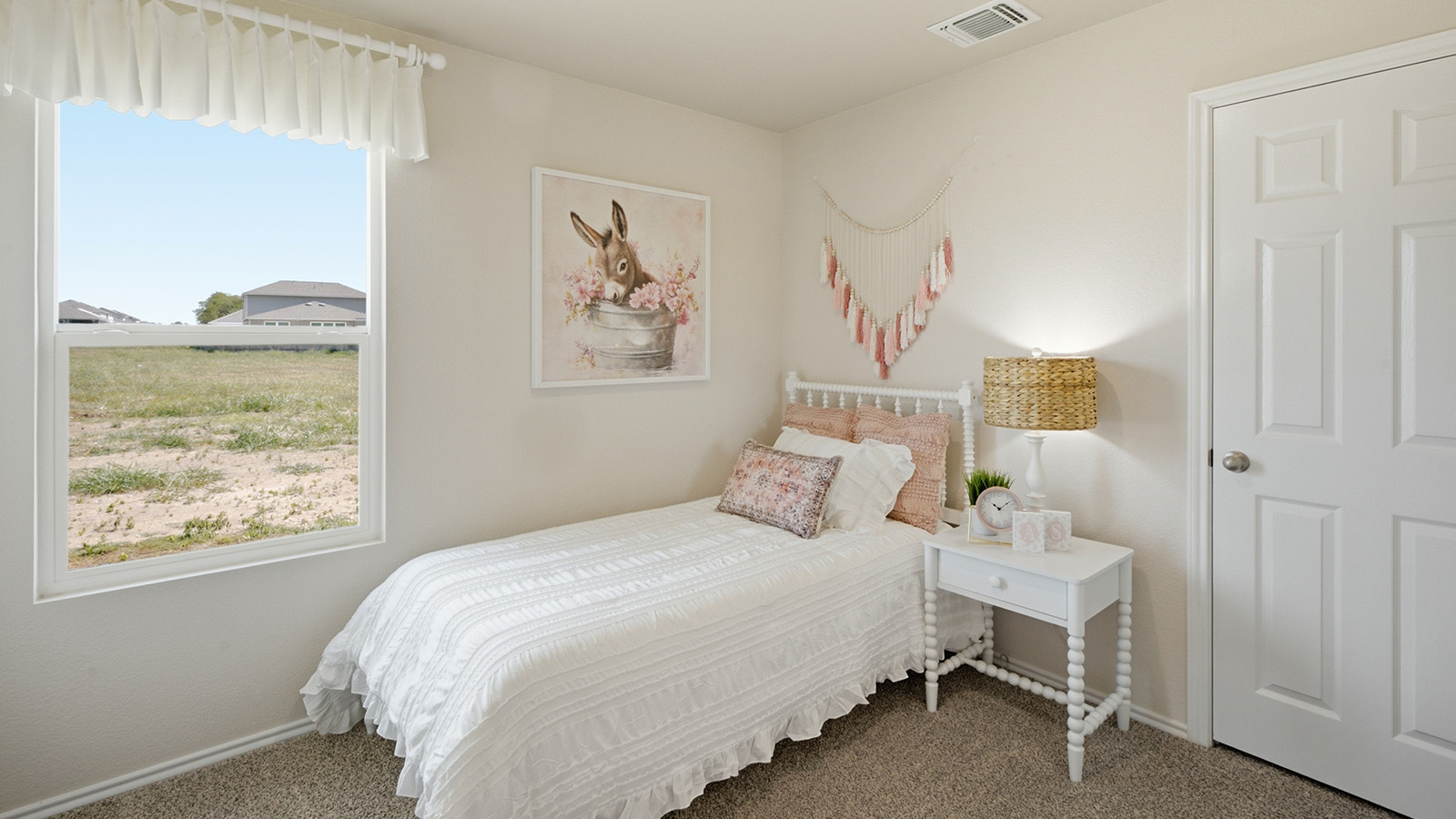 Hidden Trails Model Home secondary bedroom with carpeted flooring and window for natural lighting.