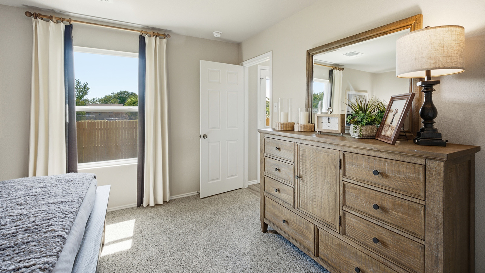 Hidden Trails Model Home primary bedroom with carpeted flooring and window for natural lighting.