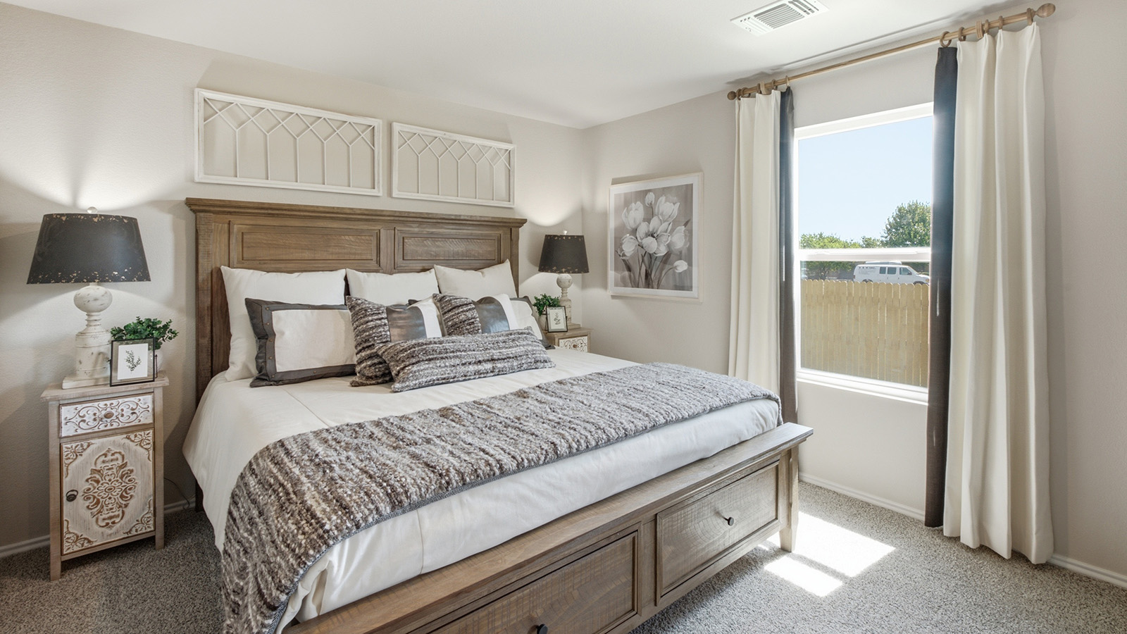 Hidden Trails Model Home primary bedroom with carpeted flooring and window for natural lighting.
