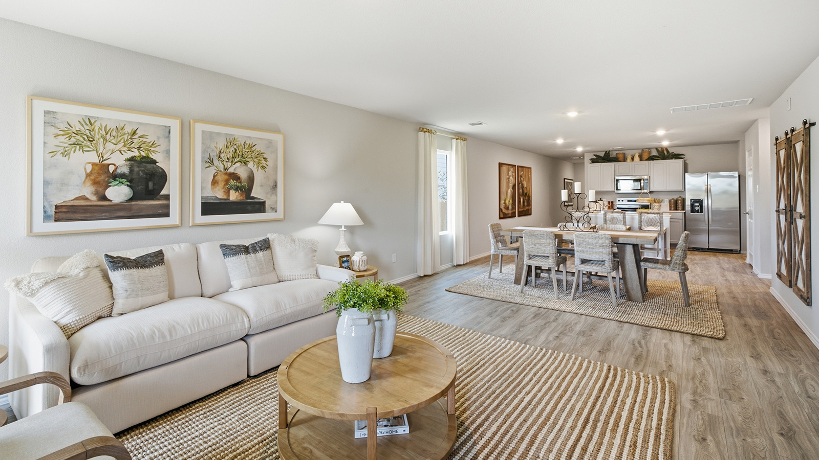 Hidden Trails Model Home living room with view of open concept dining room and kitchen.