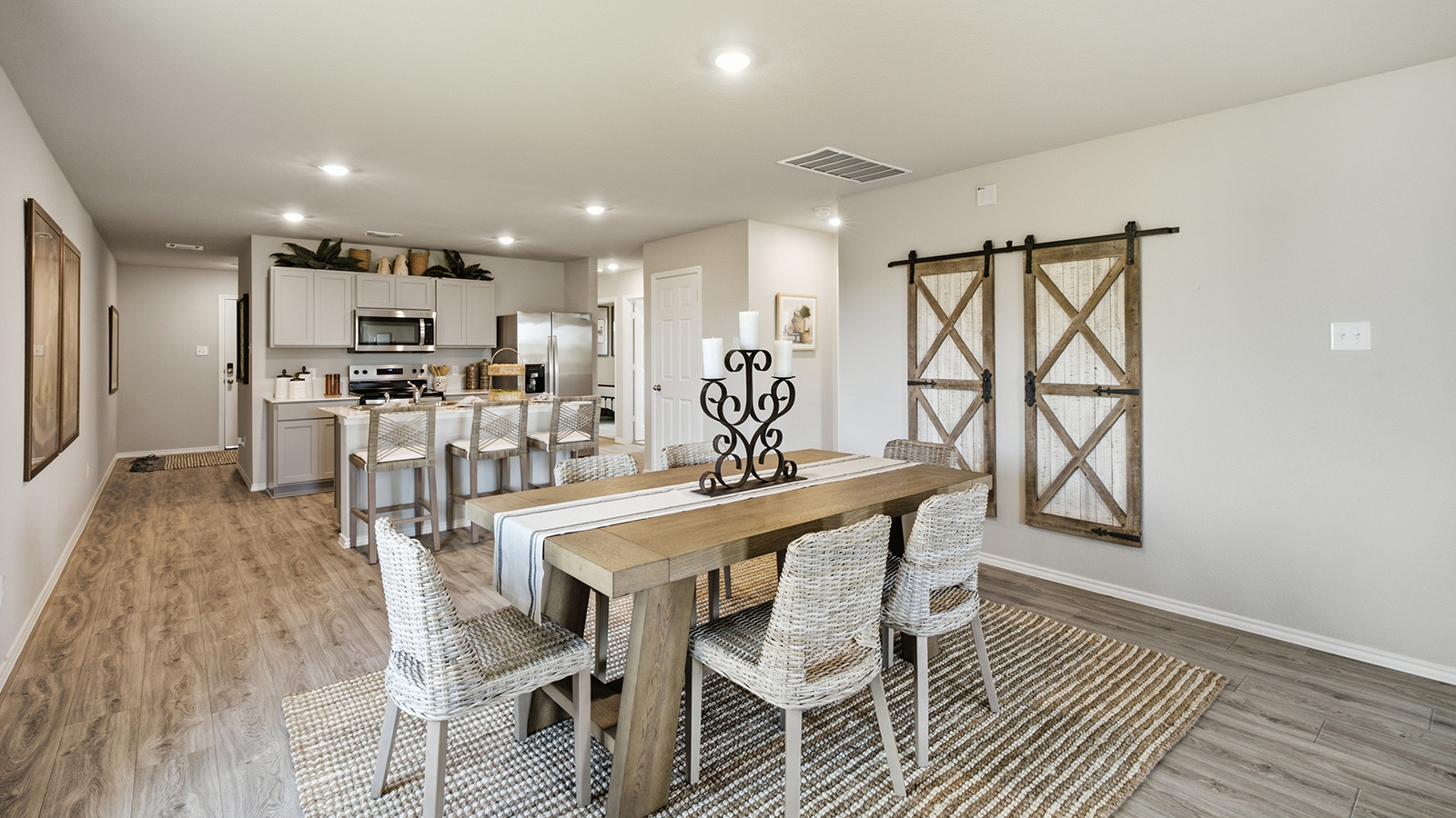 Hidden Trails Model Home dining room with view of open concept kitchen with windows for natural lighting.