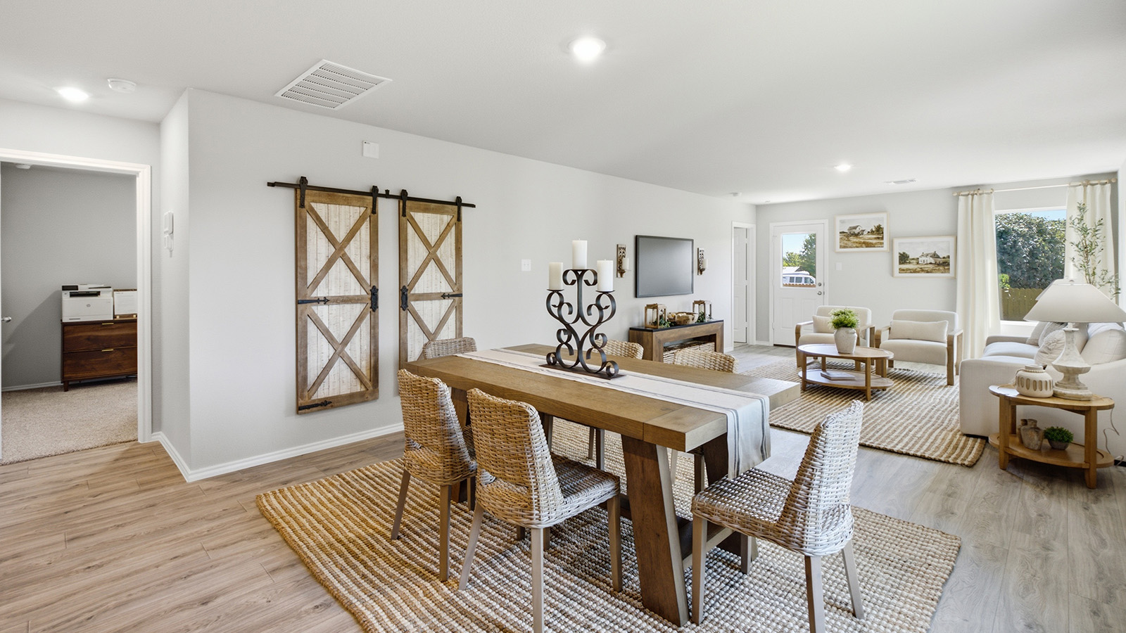 Hidden Trails Model Home dining room with view of open concept living room and windows for natural lighitng.
