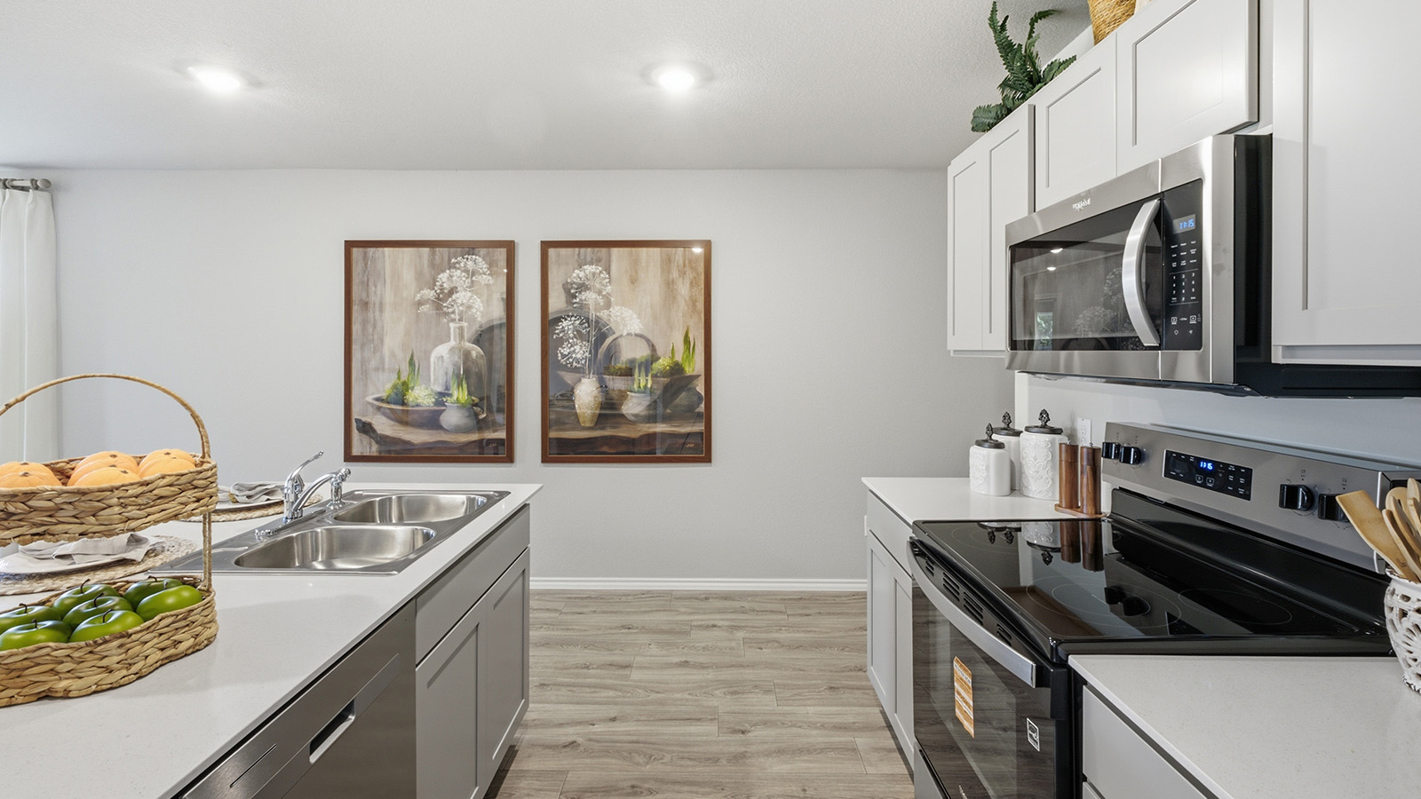 Hidden Trails Model Home kitchen with light cabinets and granite countertops with stainless steel appliances.