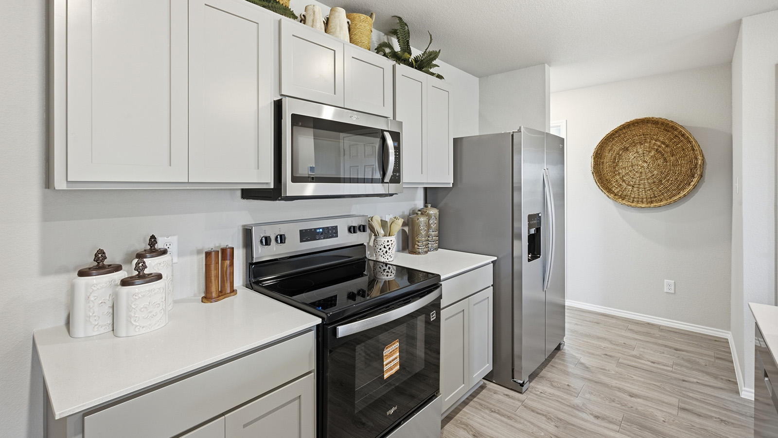Hidden Trails Model Home kitchen with light cabinets and granite countertops with stainless steel appliances.