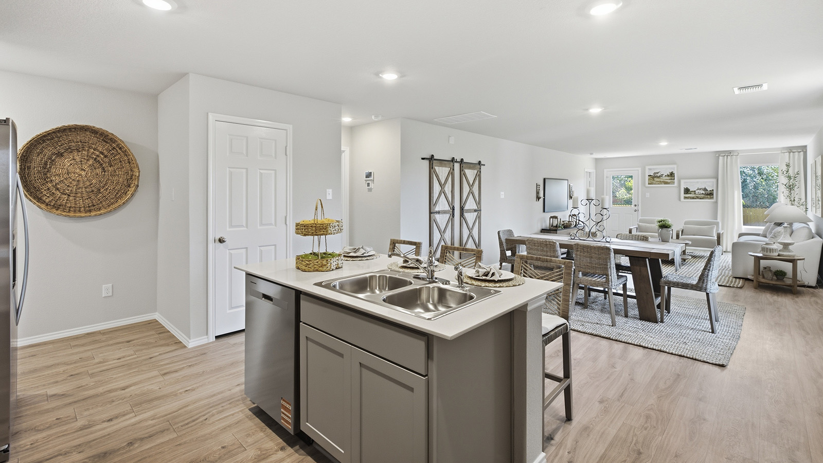 Hidden Trails Model Home kitchen with kitchen island and view of open concept dining room and living room.