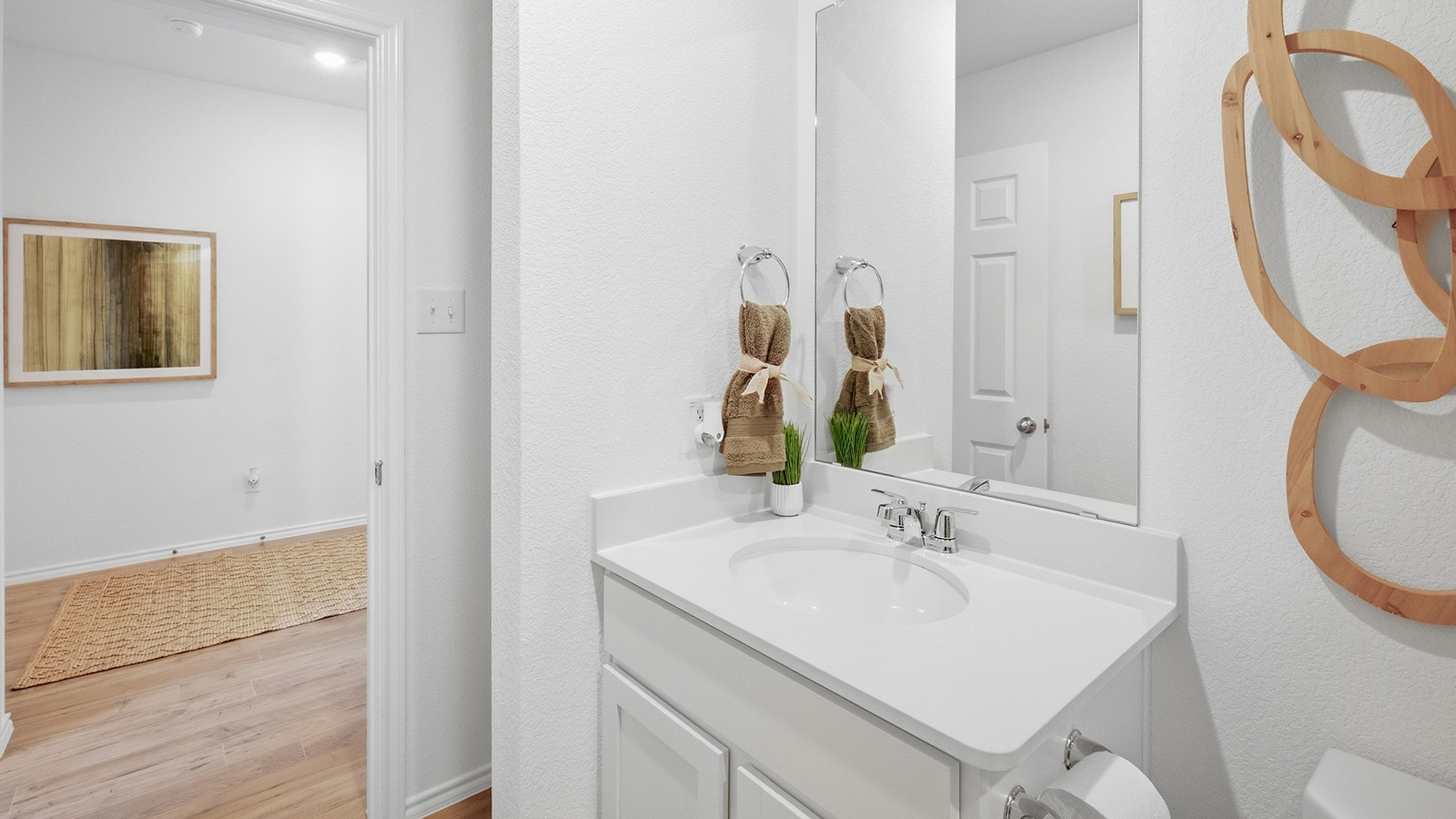 Wildwood Model secondary bathroom with vanity sink and view of hallway.