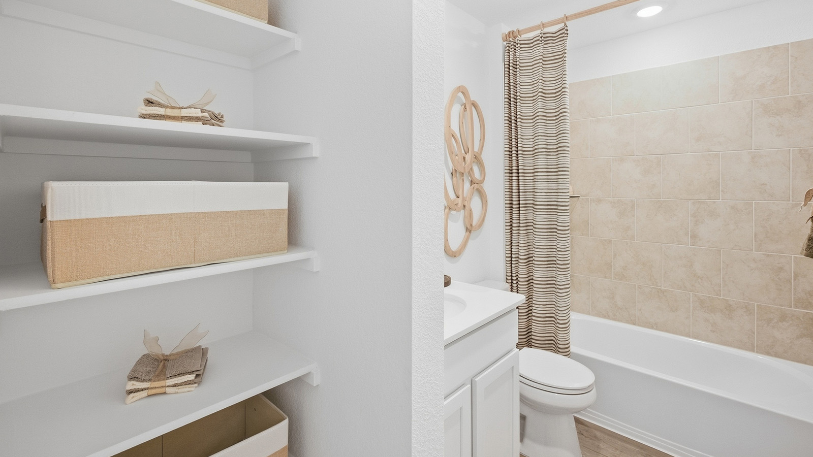 Wildwood Model secondary bathroom with shelving for storage and shower and tub combo.