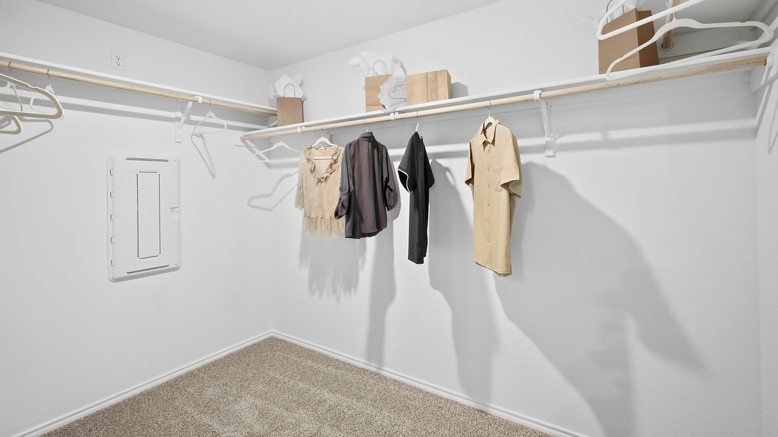 Wildwood Model primary bedroom closet with carpeted flooring and shelving for storage.