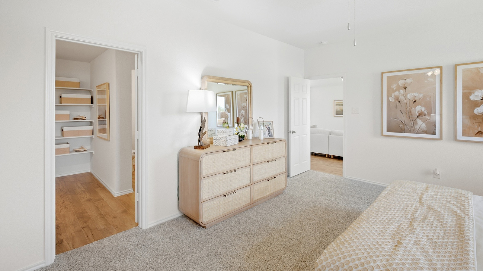 Wildwood Model primary bedroom with carpeted flooring and view of primary bathroom.