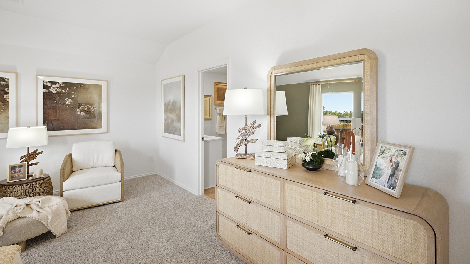 Wildwood Model primary bedroom with carpeted flooring and view of primary bathroom.