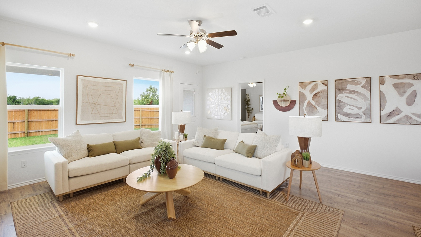 Wildwood Model living room with view of open concept dining room and primary bedroom.