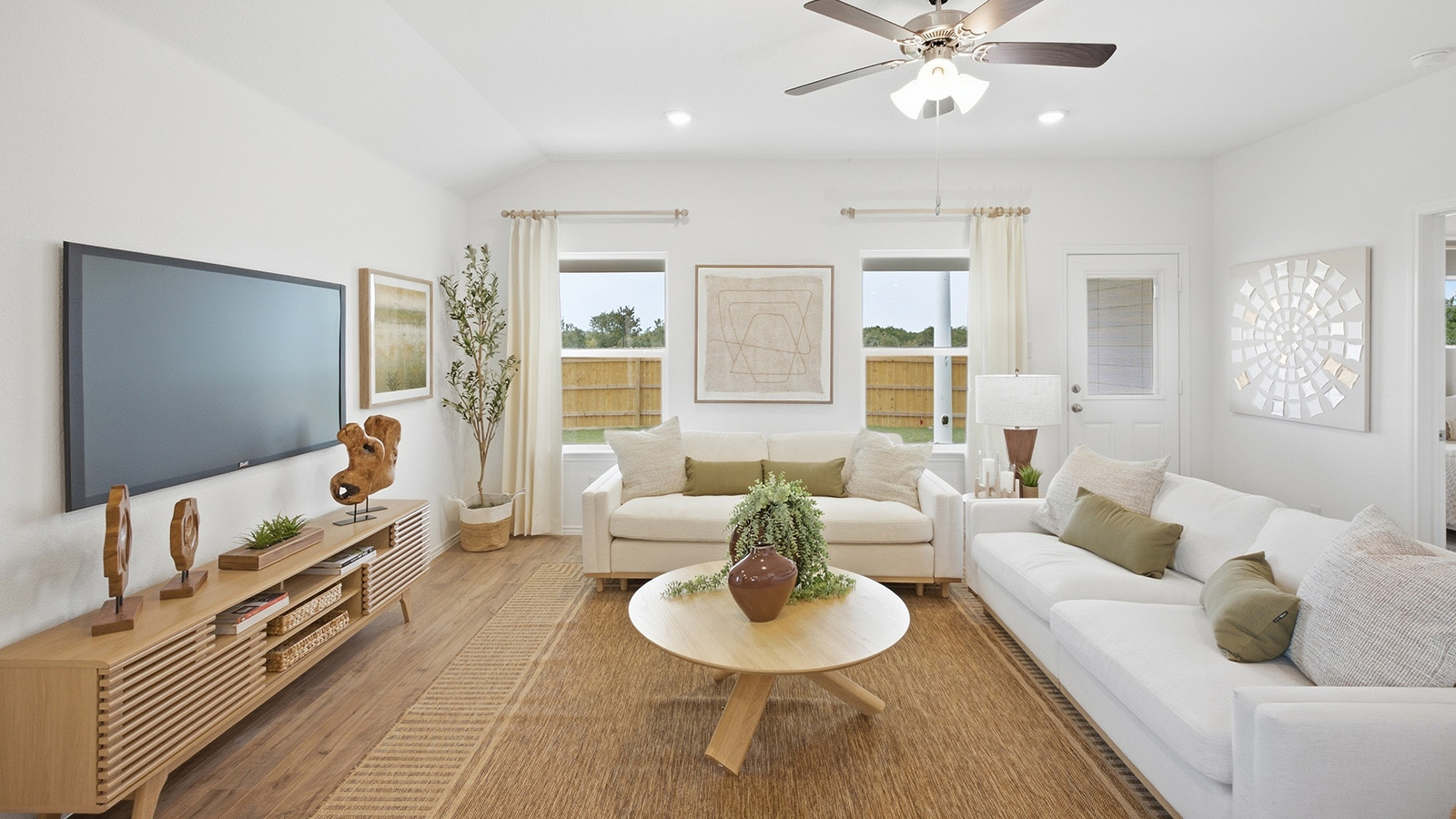 Wildwood Model living room with windows for natural lighting and view of backyard.