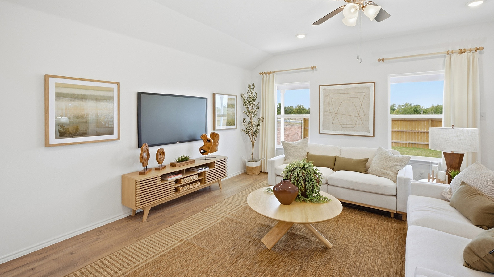 Wildwood Model living room with windows for natural lighting and view of backyard.