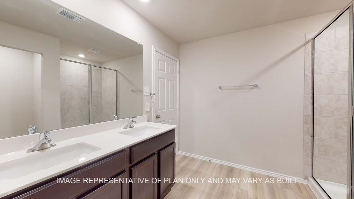 Bellvue primary bath with dark cabinets and white countertops and vinyl plank flooring.