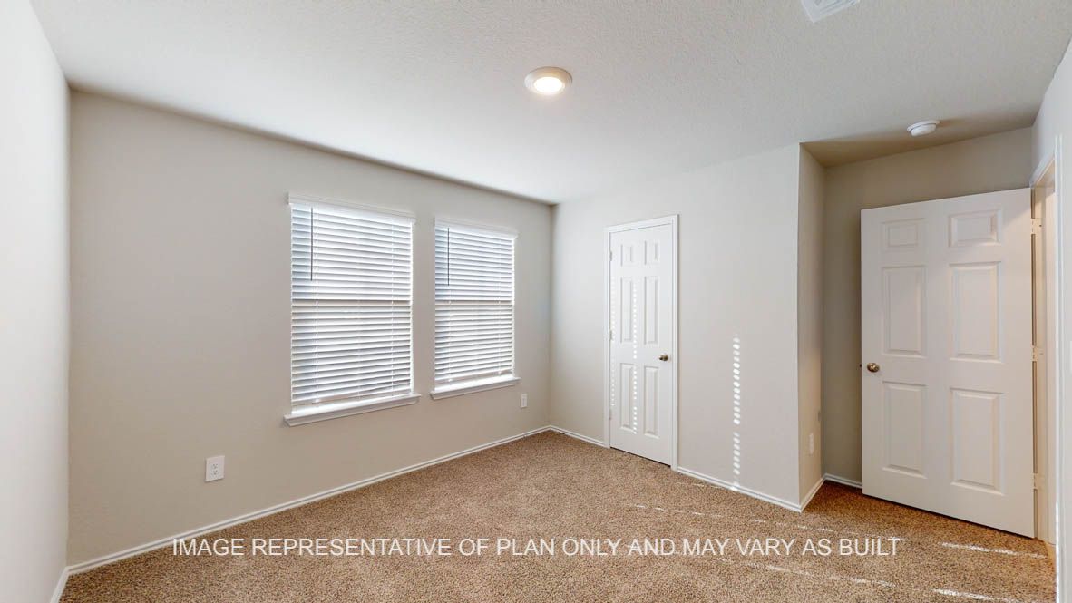 Texas Cali secondary bedroom with carpet flooring and window.