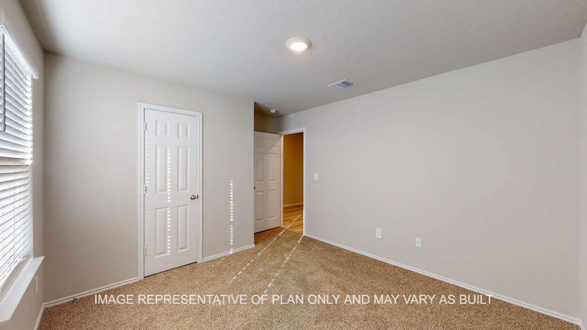 Texas Cali secondary bedroom with carpet flooring and closet door.