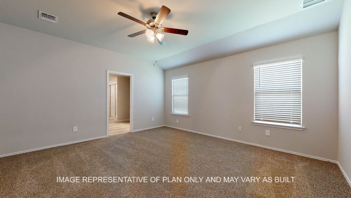Seabrook primary bedroom with carpet flooring, windows and access into adjoining bathroom.