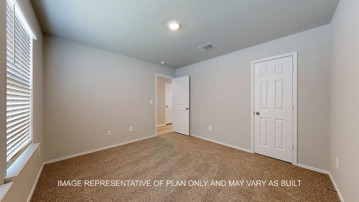 Seabrook secondary bedroom with carpet flooring and windows.