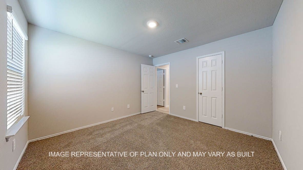 Seabrook secondary bedroom with carpet flooring and windows.