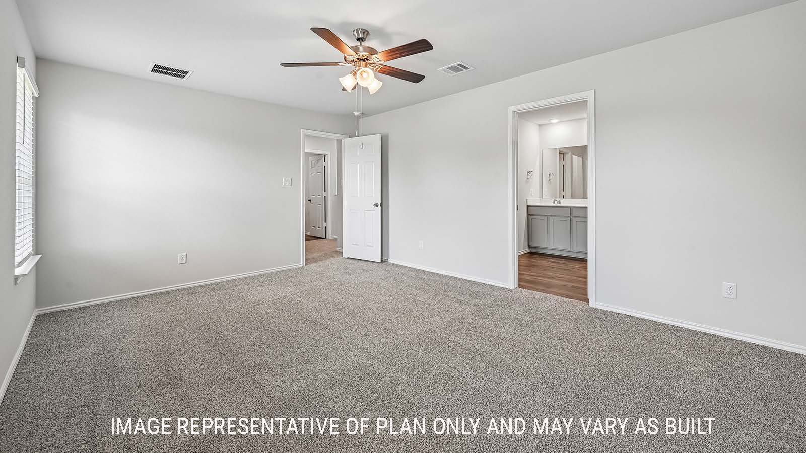Madison primary bedroom with carpeted flooring and view of primary bathroom.
